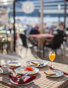 einen Tisch mit Teller mit Lebensmitteln und ein Glas Orangensaft in der Unterkunft Seafront rooms Koluna in Komiža