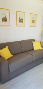 a couch with two yellow pillows in a room at Your home in Letojanni in Letojanni