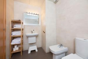 a bathroom with a sink and a toilet and a mirror at Apartamentos Cornellalux in Cornellà de Llobregat