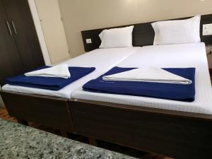 a bed with blue and white towels on it at Hotel Hanuman in Mangalore