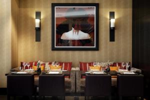 a dining room table with a picture on the wall at Eastwest Hôtel in Geneva