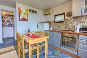 a kitchen with a wooden table with chairs and a table at Apartments Rita in Lovran +13 photos