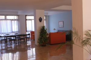 a living room with a table and chairs and a plant at APARTAMENTOS EL VELERO VIP in Torremolinos