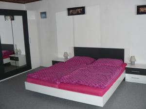 a large bed with a purple comforter in a bedroom at Apartmán U paní Věrky in Sloup