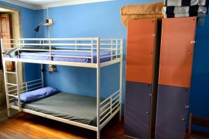 Pokój z 2 łóżkami piętrowymi i niebieską ścianą w obiekcie Albergue O Fogar de Teodomiro w Santiago de Compostela