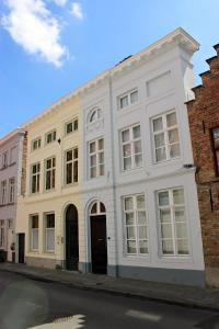 un bâtiment blanc sur le côté d'une rue dans l'établissement B&B Next Door, à Bruges