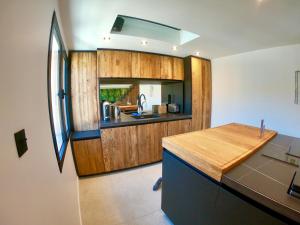 eine Küche mit Holzschränken und einer Arbeitsplatte in der Unterkunft CASA JUNGLE ! Superb duplex apartment, Place des LICES ! in Saint-Tropez