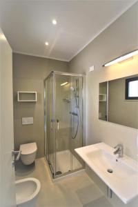 uma casa de banho com um chuveiro, um lavatório e um WC. em Hotel Marelba em Cavo