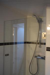 a shower with a shower head in a bathroom at Boathotel Rotterdam Anna in Rotterdam