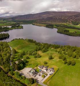 an aerial view of a house next to a lake at The Rowan Tree Country Hotel in Aviemore