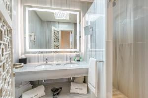 
a bathroom with a sink, mirror and bath tub at Hotel Saray in Granada
