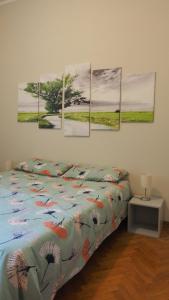 una camera da letto con un letto con quattro dipinti sul muro di Ferrari Suite Modena a Modena