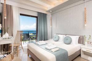 a bedroom with a bed with a view of the ocean at Hotel Villa Natassa in Skala Rachoniou +37 photos