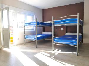 2 łóżka piętrowe w pokoju z oknem w obiekcie Albergue Mar de Rostro w mieście Fisterra