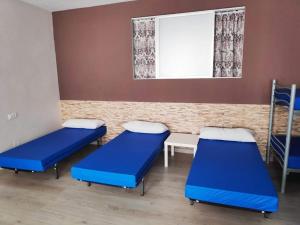 a hospital room with blue beds and a window at Albergue Mar de Rostro in Finisterre +25 photos