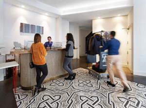 a group of people standing at a counter in an office at One Shot Prado 23 in Madrid