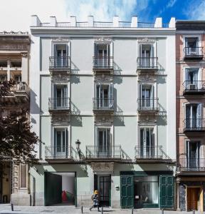un gran edificio blanco con puertas verdes y balcones en One Shot Prado 23, en Madrid