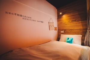 een slaapkamer met een bed met een bord aan de muur bij Kenting Original Hostel in Kenting