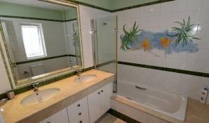 y baño con 2 lavabos, bañera y espejo. en Mogán suite, en Puerto de Mogán