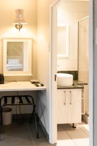 a bathroom with a sink and a desk with a mirror at Greenwaywoods Unit 11 in White River