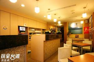 a restaurant with a bar and tables and chairs at Tanxiang Resort Hotel Sun Moon Lake Harbour - Sun Moon Lake Pier in Yuchi