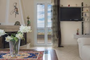 Una sala de estar con un jarrón de flores sobre una mesa. en Villa Palma, en Sitia