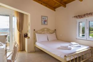 1 dormitorio con 1 cama con sábanas blancas y 2 ventanas en Villa Palma, en Sitia 37 fotos más