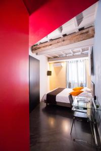 1 dormitorio con cama y pared roja en Nerva Accommodation, en Roma