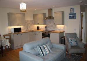 a living room with a couch and a kitchen at Callie's Cottage in North Berwick