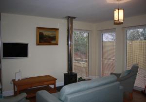 uma sala de estar com 2 sofás e uma televisão de ecrã plano em Callie's Cottage em North Berwick