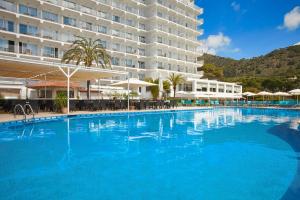 a large swimming pool in front of a hotel at Universal Hotel Castell Royal in Canyamel