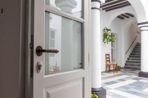 a white door with a glass window on a hallway at Casa Convento in Vejer de la Frontera