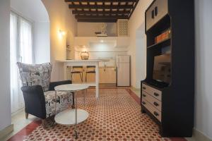 a living room with a table and a kitchen at Casa Convento in Vejer de la Frontera +11 photos
