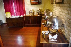 a kitchen with a bunch of pans on a counter at Majkhali Woods, Ranikhet, By Himalayan Eco Lodges in Rānīkhet