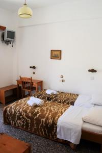 A bed or beds in a room at Esperia Home Style Pension