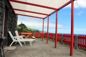 a patio with two white chairs and a table at Casa da Aguada in Lajes do Pico