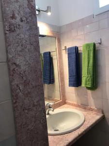 y baño con lavabo, espejo y toallas. en Beachfront House Geremeas Sardegna, en Geremèas