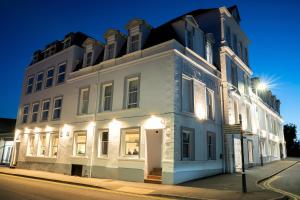 a large white building on a street at night at County Hotel in Kendal