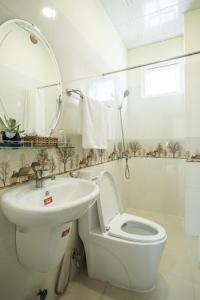 biała łazienka z toaletą i umywalką w obiekcie LuTo Hotel w mieście Da Lat