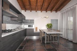 a kitchen with a table and chairs and a kitchen with a stove at Les Maisons - Ruculì Hospitality in Tignale