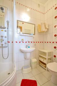 uma casa de banho com um chuveiro, um lavatório e um WC. em Apartament Zuzia em Dźwirzyno