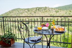 a table with breakfast food on a balcony with a view at Valle Del Buttero in Capalbio