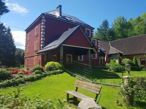 une maison avec un banc devant elle dans l'établissement Miodowy Raj, à Targanice