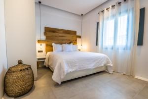 sypialnia z białym łóżkiem i oknem w obiekcie Portes Suites & Villas Mykonos w mieście Mykonos