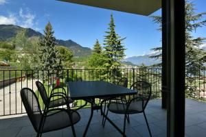 a table and chairs on a balcony with a view at Villa San Valentino - Ruculì Hospitality in Tignale