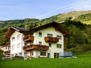 une grande maison blanche avec balcon sur une colline dans l'établissement Landhaus Gastein, à Dorfgastein