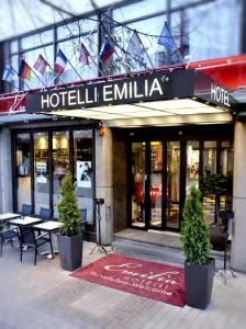 un hôtel emilia avec des tables et des chaises devant un bâtiment dans l'établissement Hotel Emilia, à Hämeenlinna