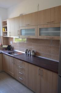 a kitchen with wooden cabinets and a black counter top at Dream Villa in Sarajevo +17 photos