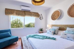 a bedroom with a large bed and a blue couch at The Lovely House in Ibiza Town