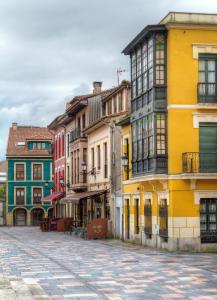 una calle en un casco antiguo con edificios coloridos en Oca Villa de Avilés Hotel, en Avilés